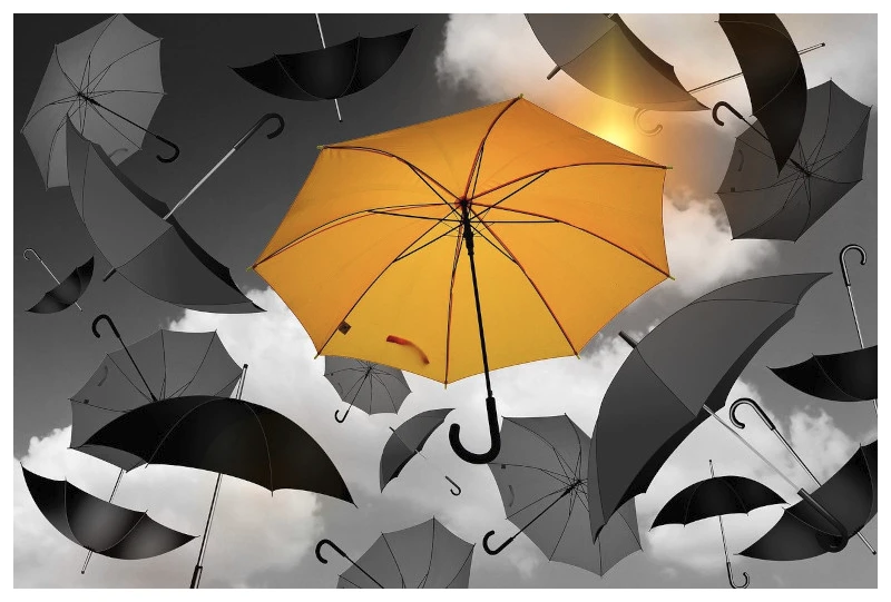 A yellow umbrella among the grey umbrellas